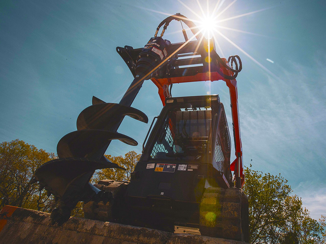 Image showing Danuser EP 615 Auger Drive mounted on Toro Mini Skid Steer positioned on top of an elevated concrete slab