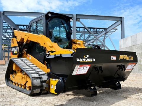 Image showing Danuser Mega Mixer on CAT 289D Skid Steer at construction site with steel framework visible in the background