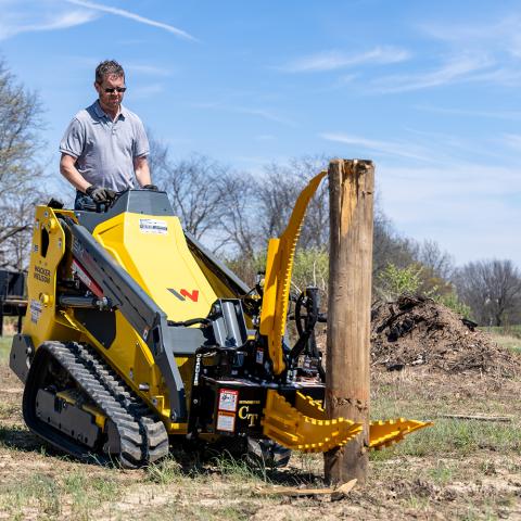Intimidator CT mounted to mini-skid-steer pulling a wood post